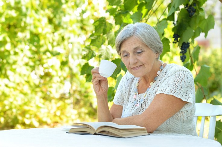 Lady drinking cup of tea in the garden
